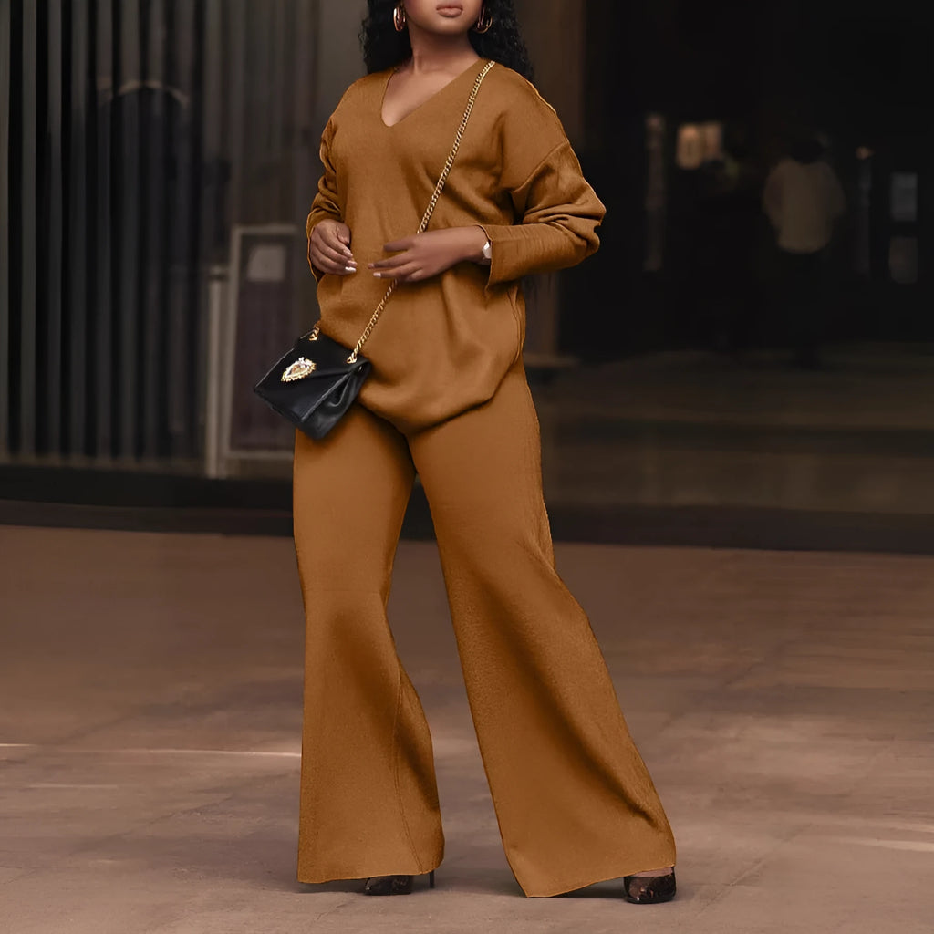 Women's brown suede two-piece suit with split sleeve top and full-length trousers on a model.