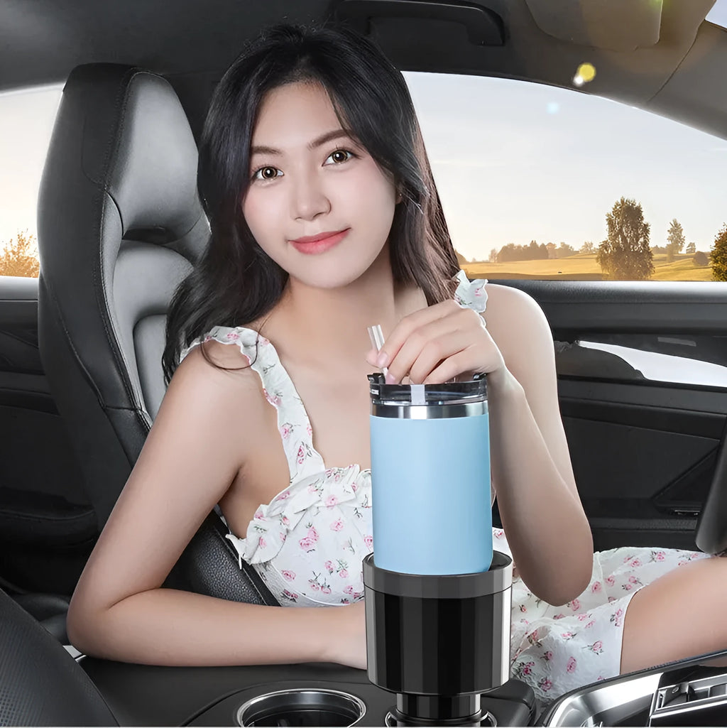Matte black adjustable car cup holder expander for large bottles and cups on a car centre console.