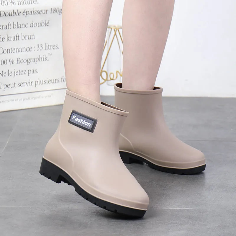 Women's mid-calf rain boots in black, PVC upper, shown with a low heel.