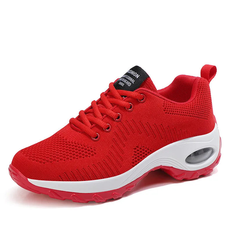 Red and black women's low-top mesh sneakers with front laces and a round toe, showing a mid-heel sole.