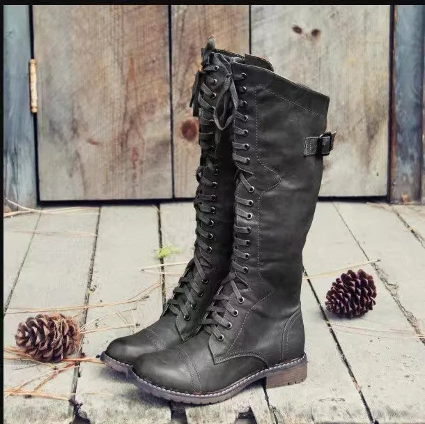 Women's black high leg boots with a chunky low heel and round toe on a plain background.