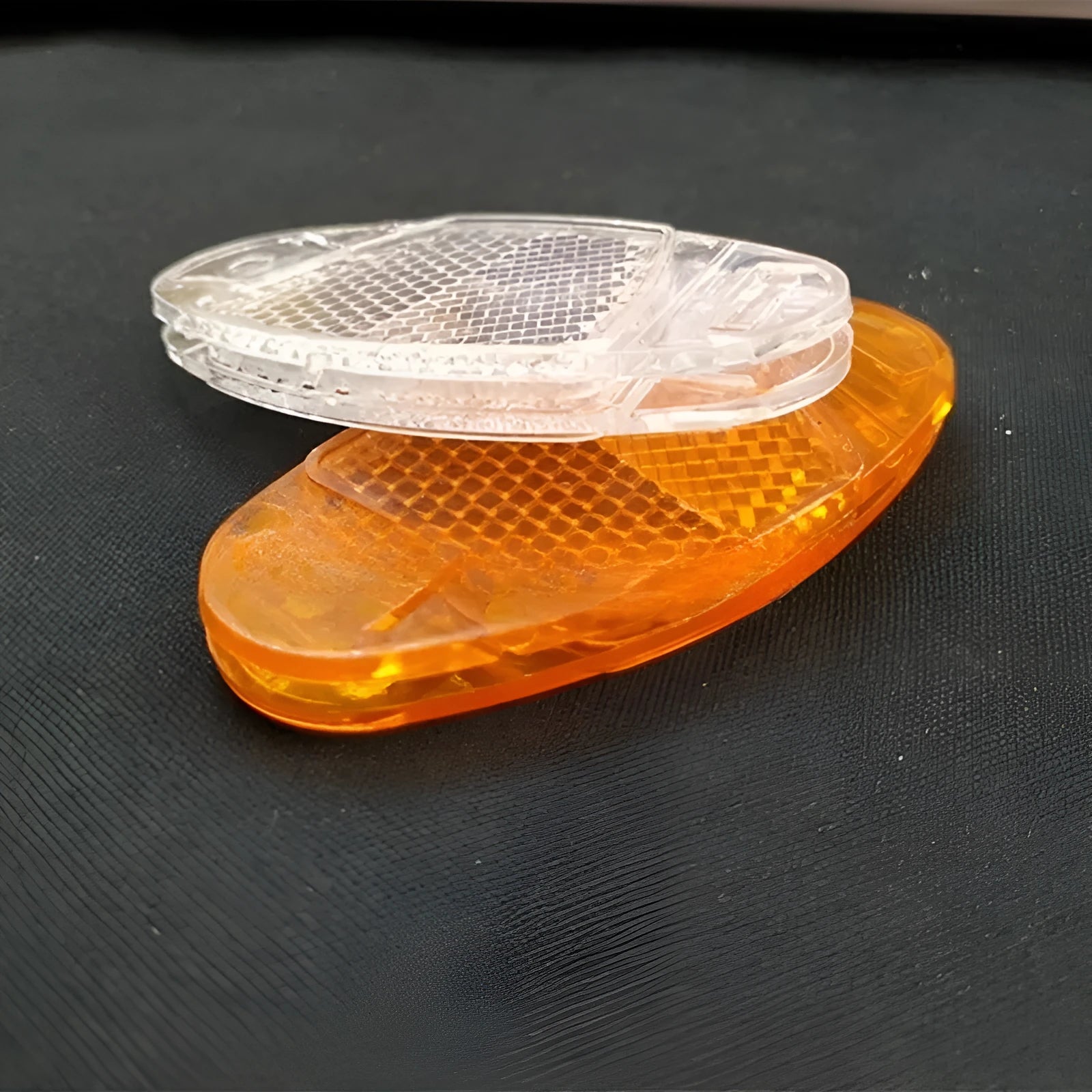 Yellow and white plastic bicycle spoke reflectors showing size of 7.2cm by 3.5cm.