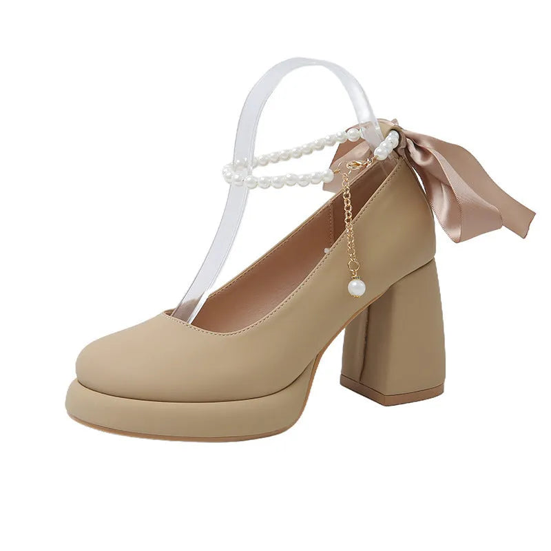 Beige women's Mary Jane shoes with a chunky heel and an ankle-strap buckle on a round toe.