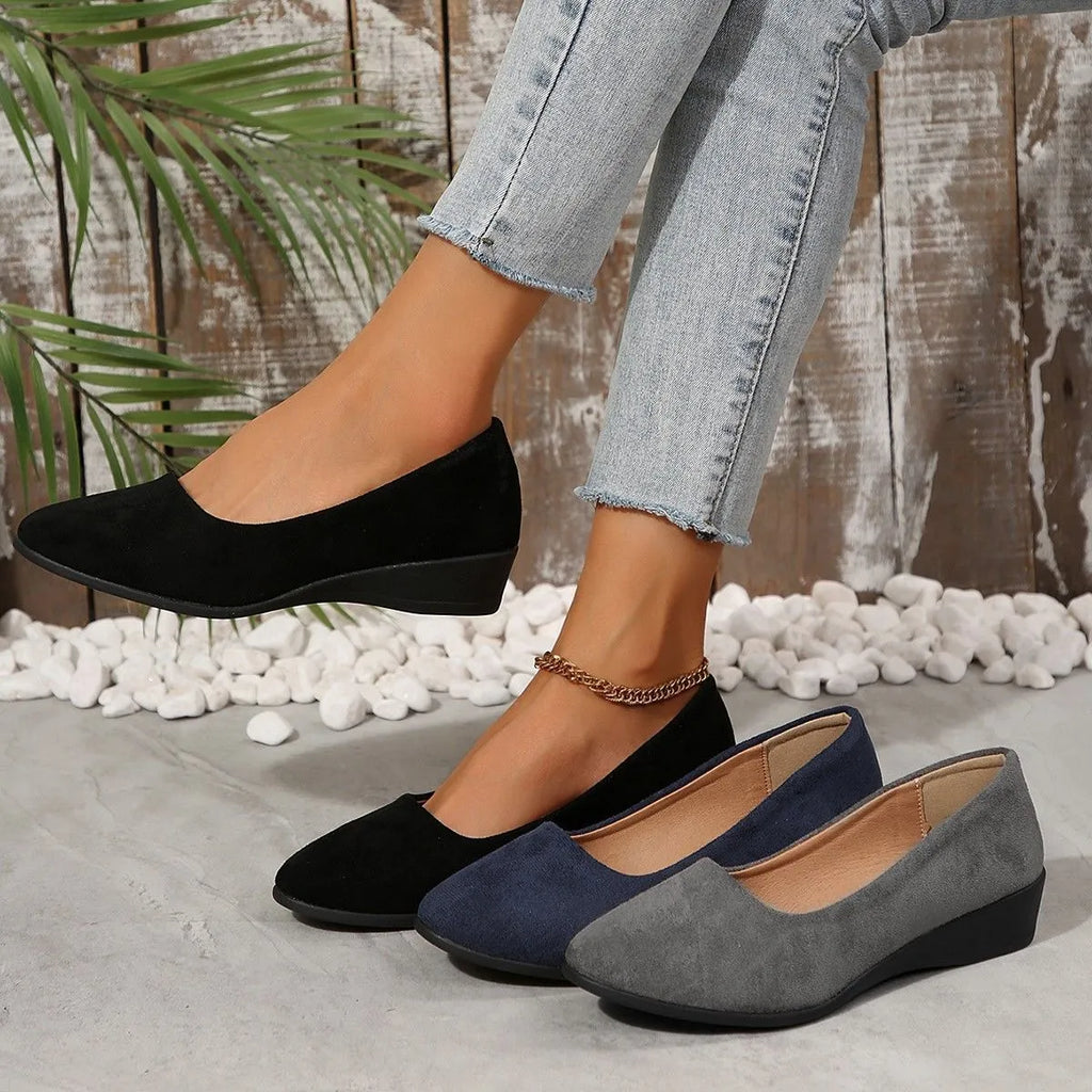 Women's suede wedge pump in light brown with pointed toe and low wedge heel.