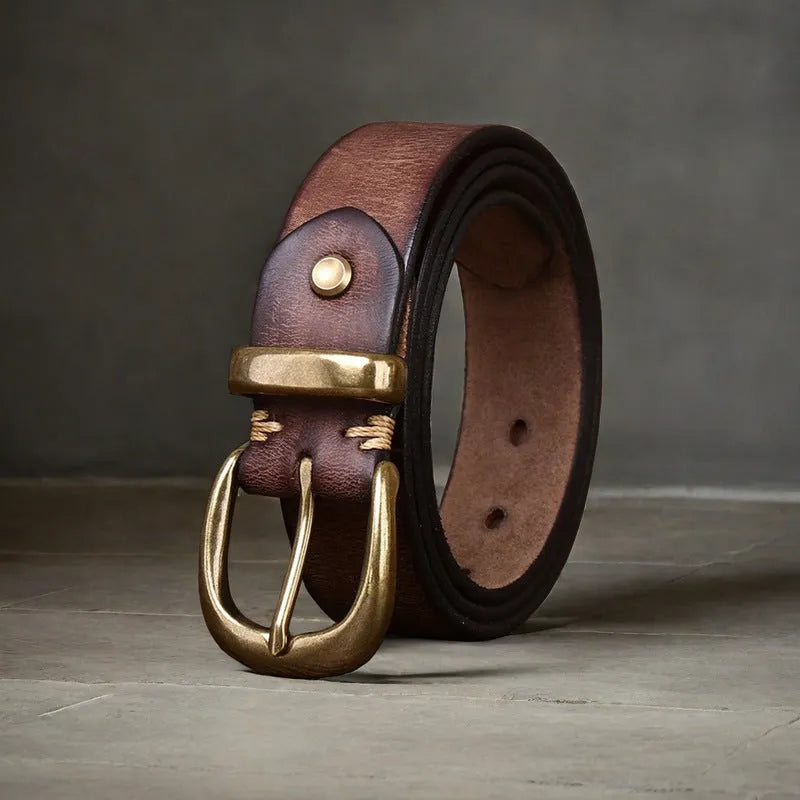 Men's black cattlehide leather belt with copper pin buckle on a pair of jeans