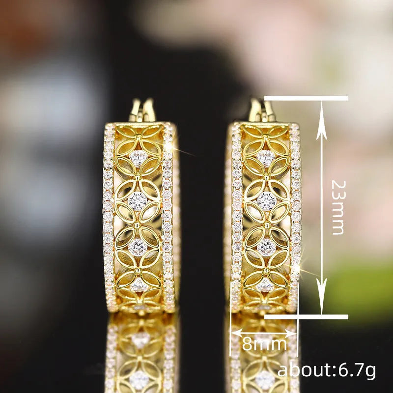 A pair of gold-coloured geometric clip-on earrings with horse, eye, flower and butterfly motifs on a copper base.