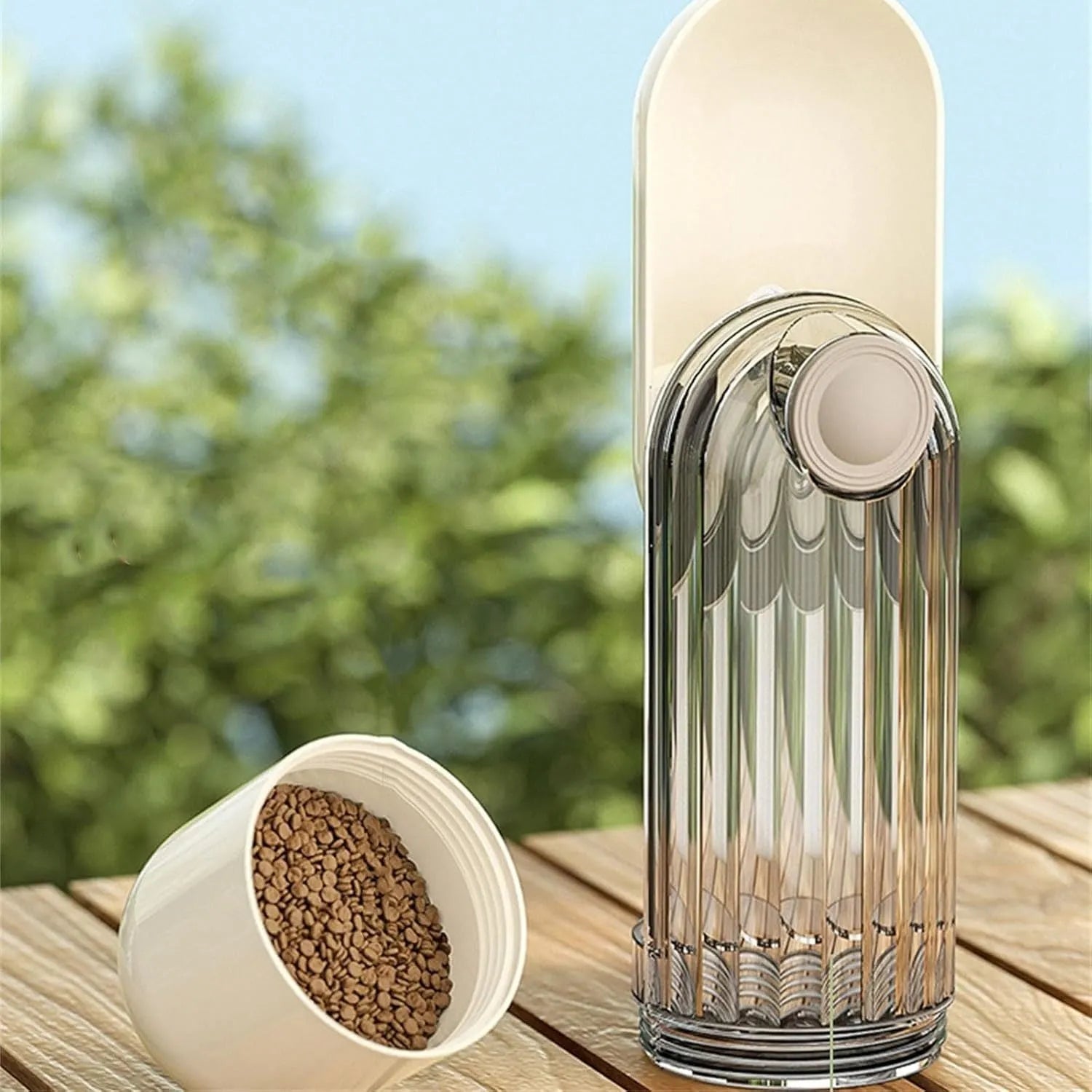 Beige foldable dog water bottle with food dispenser shown next to a dog on a walk