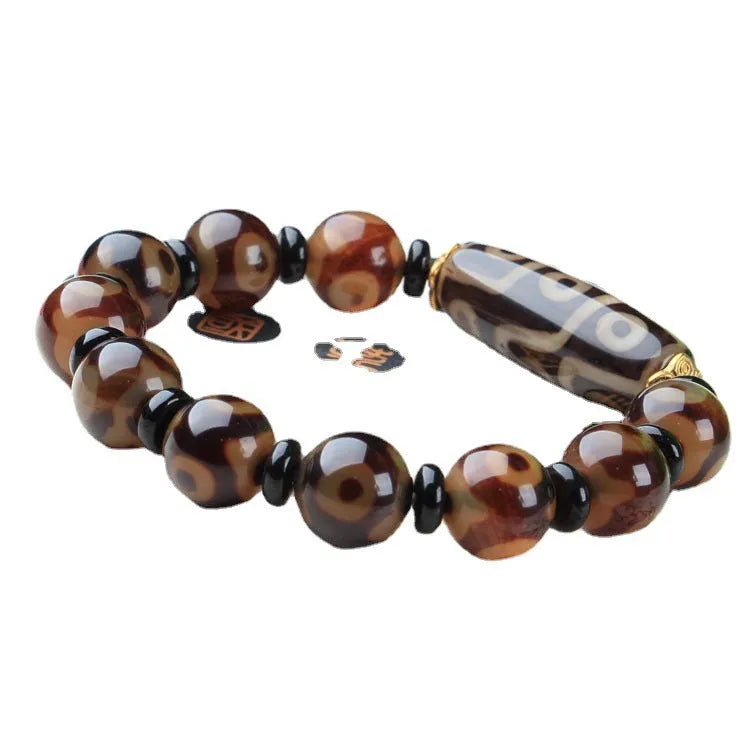 Close-up of a handmade Tibetan dzi bead bracelet with distressed agate beads in antique and frosted finishes.