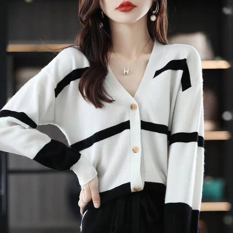Woman wearing a slim fit V-neck knitted cardigan with a black and white 3D striped pattern