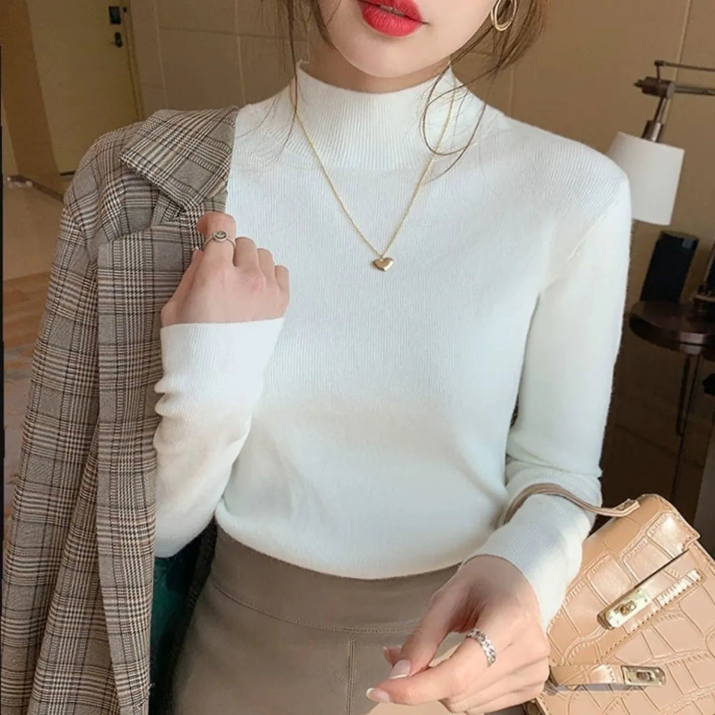 Women's slim fit long sleeve viscose knit top in a neutral colour on a hanger.