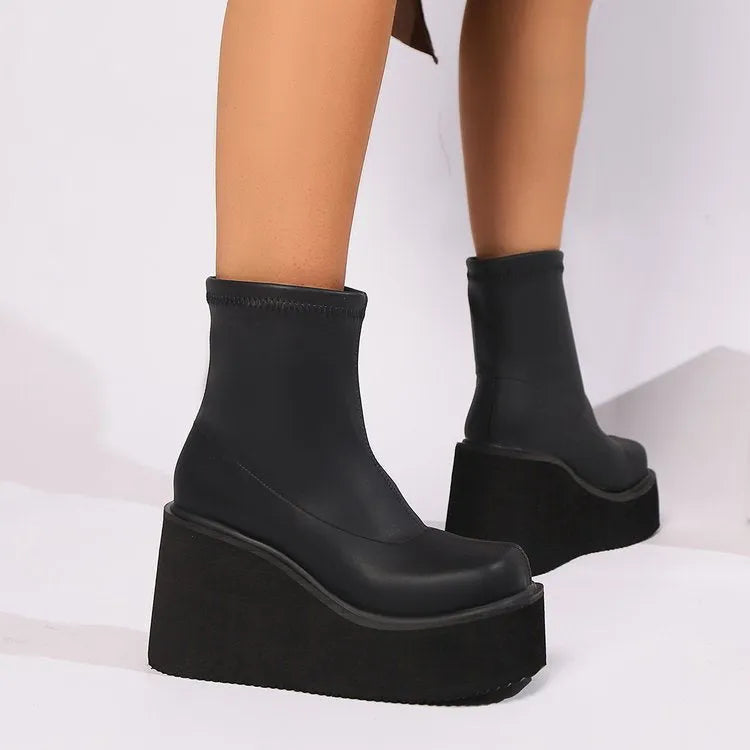 Plus size black women's boots with a wedge heel, round toe, and waterproof platform.