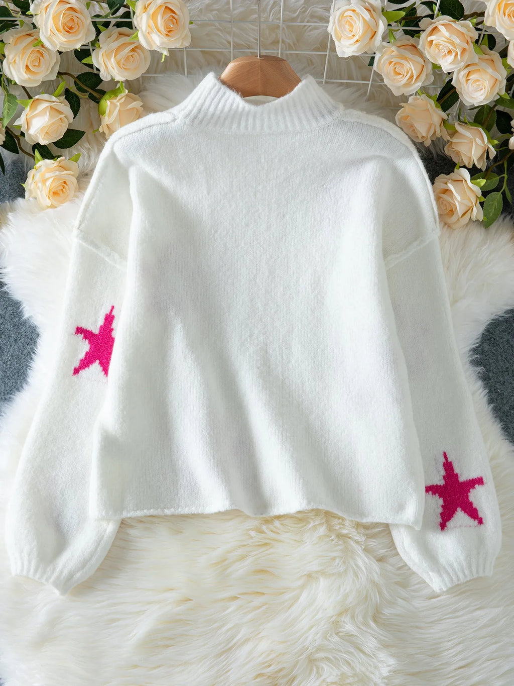 White women's loose fit turtleneck sweater with a black five-pointed star pattern on the front.