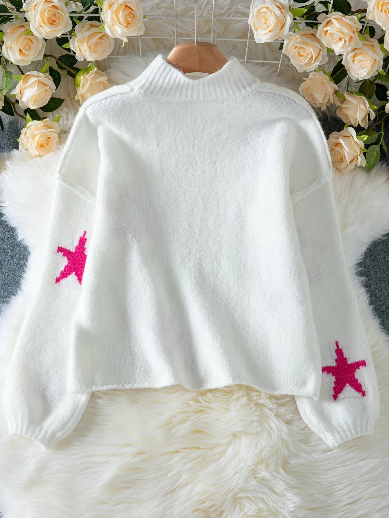 White women's loose fit turtleneck sweater with a black five-pointed star pattern on the front.