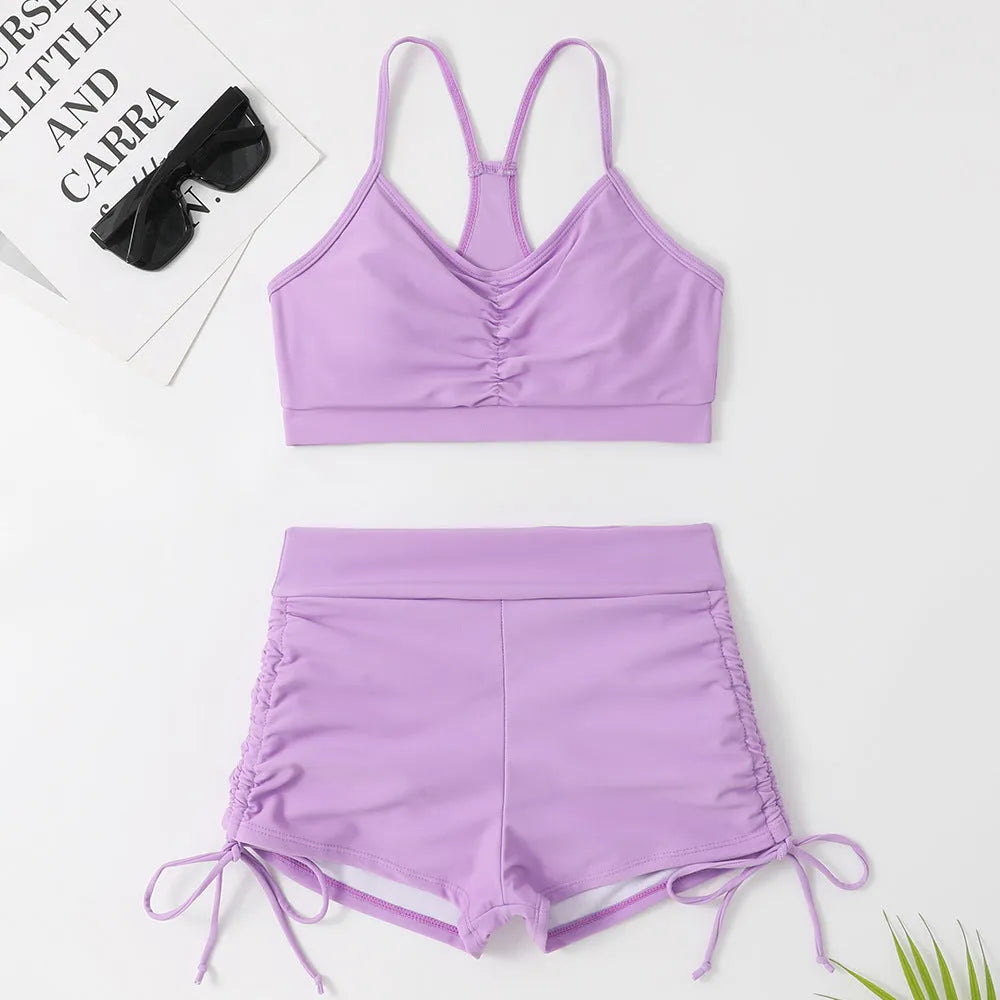Women's black high-waist bikini swimsuit with split-side shorts and brief top.