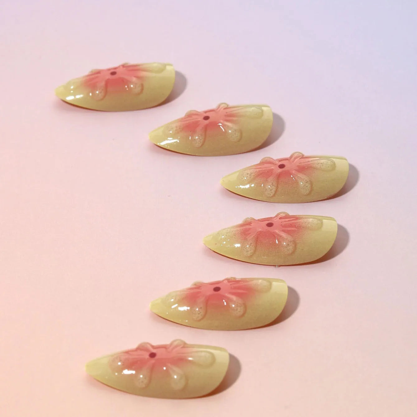 Simple fake nails with pink and white cartoon 3D flowers, shown with jelly glue tube and filing strip.