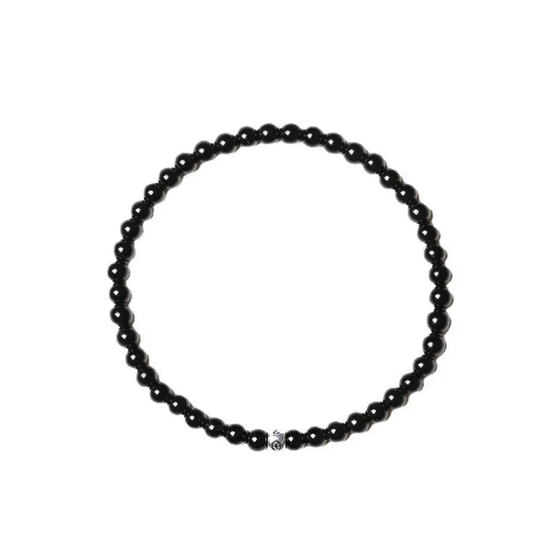 A unisex beaded bracelet with small 4mm obsidian, blue San, and black agate stones in geometric shapes.