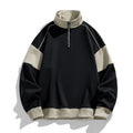 Man modelling a hooded black corduroy sweatshirt with drop shoulders and loose lapels.