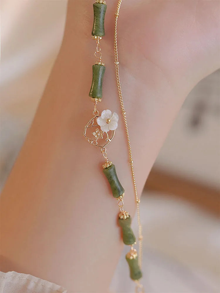 Natural olivine women's bracelet with a double layer twin bells of ireland charm and olive branch detail.