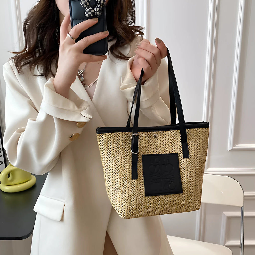 Straw woven women's shoulder bag in black with sewing thread detailing and three-dimensional pockets
