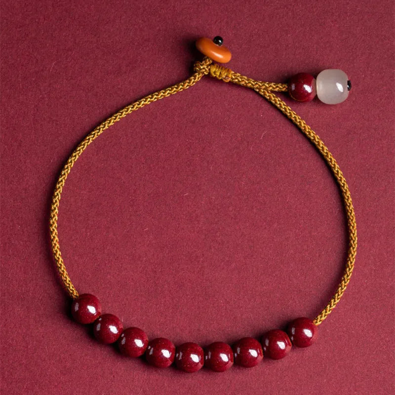 Hand-woven cinnabar and Hetian jade bracelet with geometric design showing natural colour variation