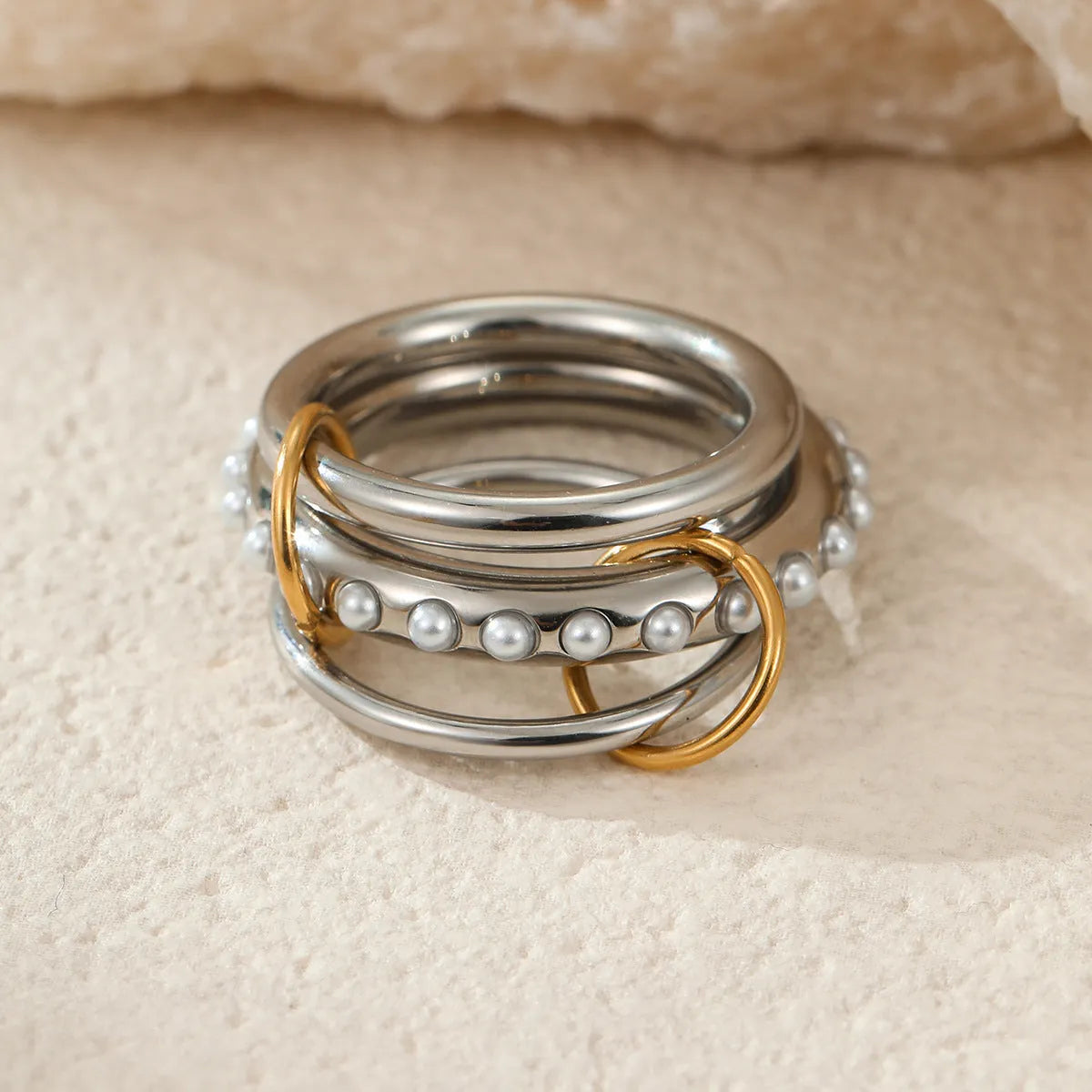 Stacked stainless steel rings with gold plating in coordinated colours showing layered hand jewellery design