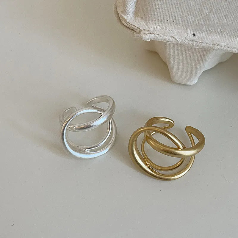 Gold and silver matte metal open rings with three-dimensional interlaced geometric design