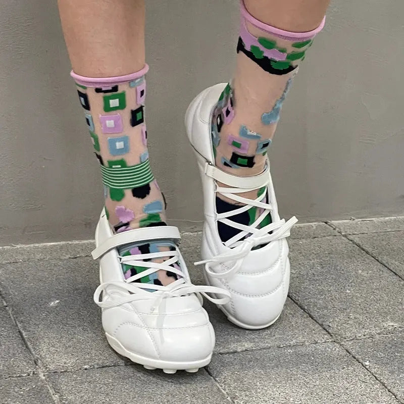 Women's silver lace-up sports shoes with a bow detail and a round toe, shown on a low-top cut.