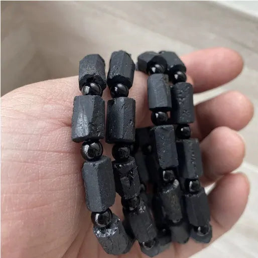 Natural black tourmaline rough stone bracelet with approximately 9mm beads on wrist