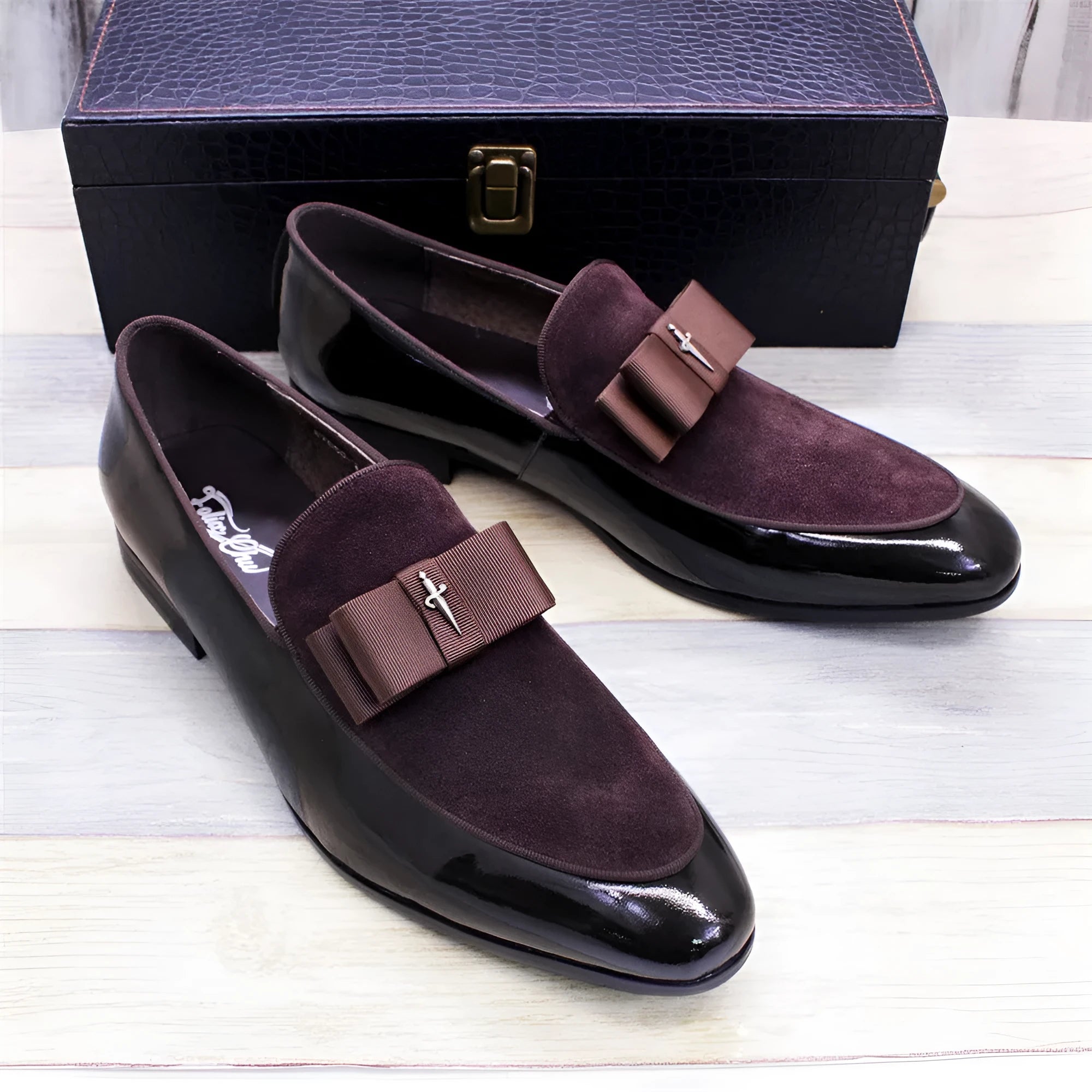 Men's low-top leather shoes in black with a tassel detail and glossy patent leather accents.