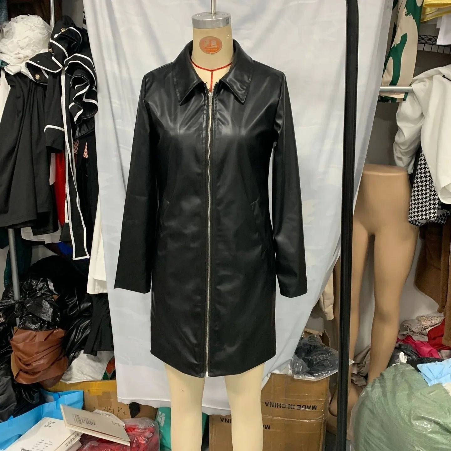 Black medium-length leather jacket for women with long sleeves.