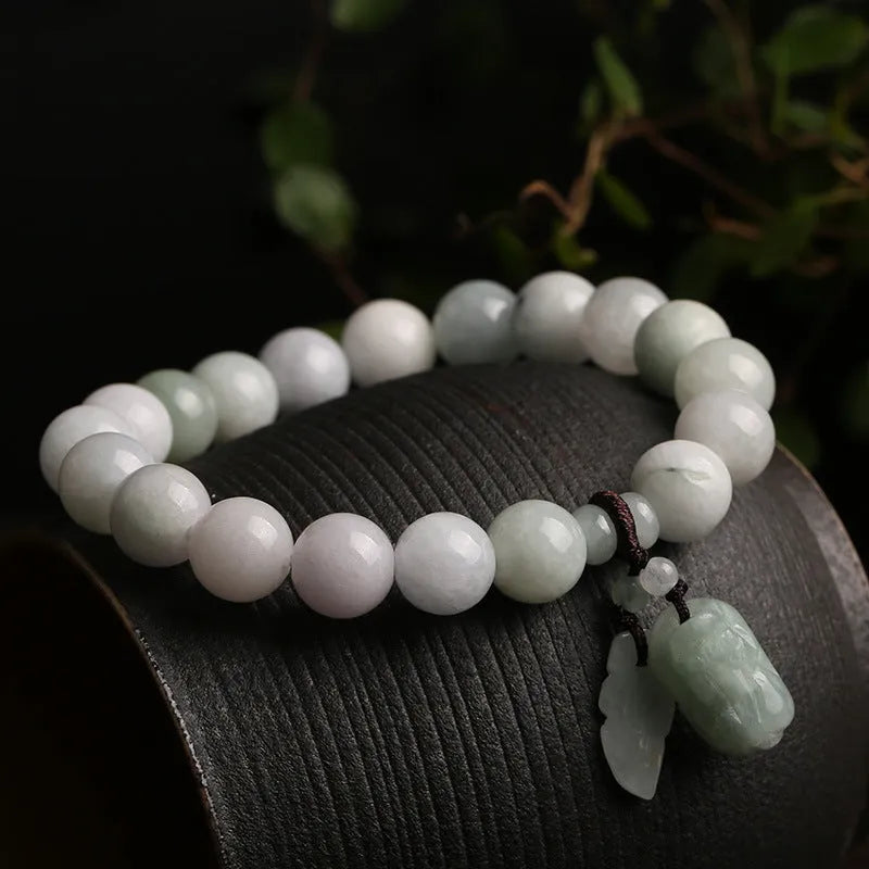 Natural green jade hanging bracelet with Maitreya Buddha pendant on a wrist.