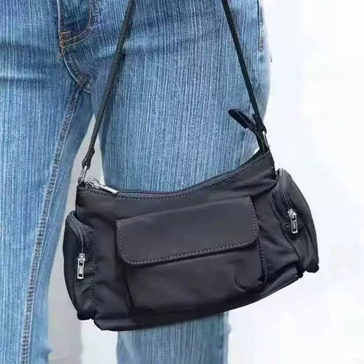 Black nylon shoulder bag with two pockets showing side line detail and 24cm dimensions