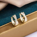 Geometric 14K yellow gold-plated earrings with zircon detailing on white background