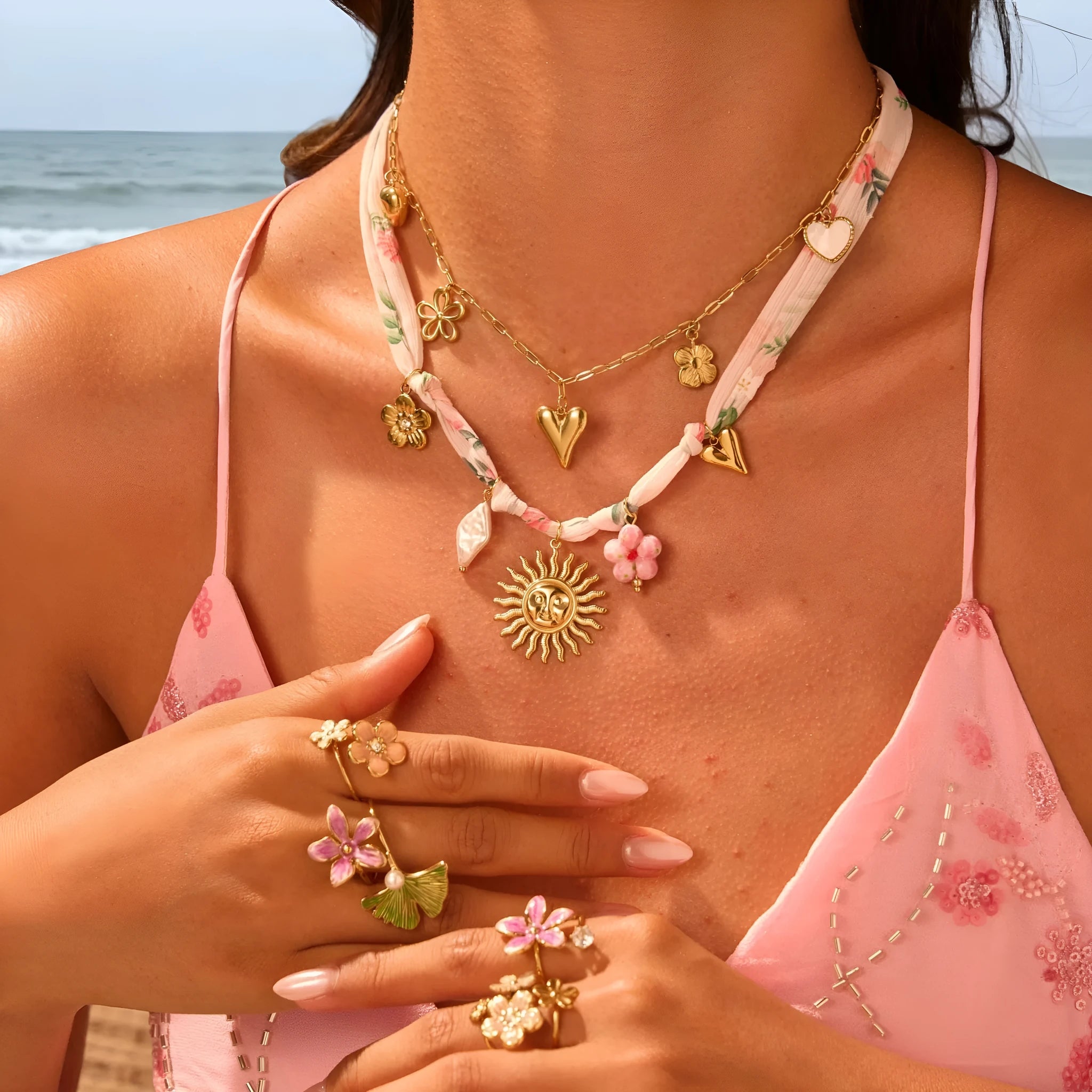 Stainless steel women's necklace with a sun pendant on a regular chain, showing heart and ribbon sun design options.