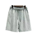 Man wearing navy blue cotton shorts with a distressed finish and a loose, straight-leg casual fit.