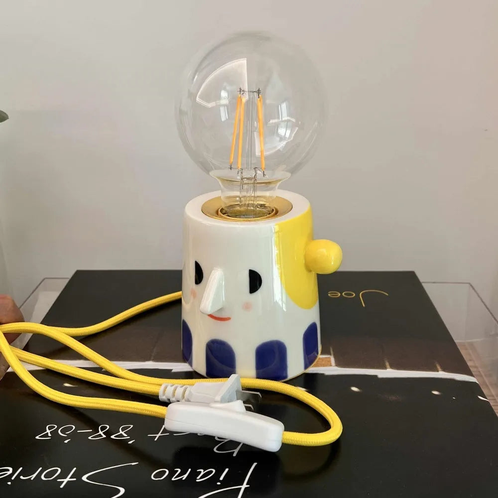 Handmade ceramic bedside lamp with ball headlight design on wooden surface