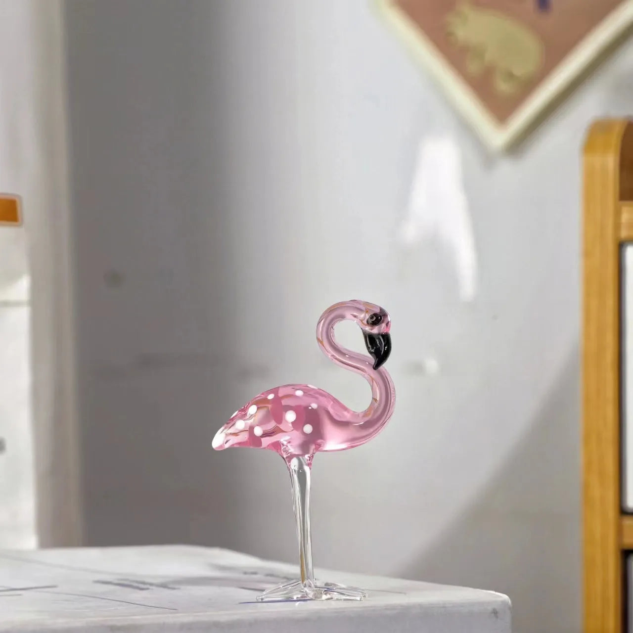 Pink crystal flamingo decorative ornament on a table, modern minimalist style.