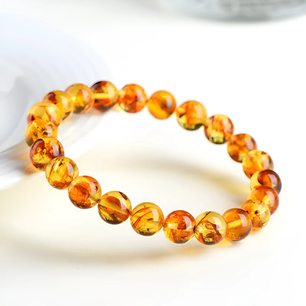 Natural yellow piebald amber beaded bracelet with geometric polished beads on a white background.