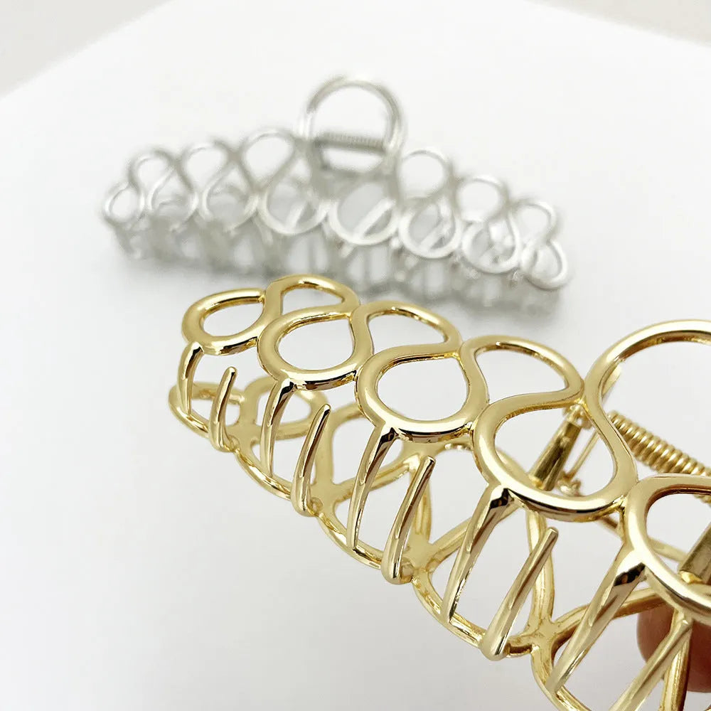 Minimalist large hair clip with electroplated alloy construction and tassel accents in gold or silver colour