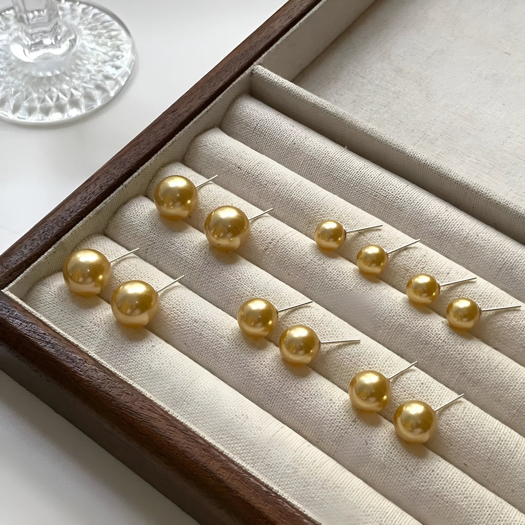 Large pearl stud earrings with geometric silver settings and eight-pointed star details