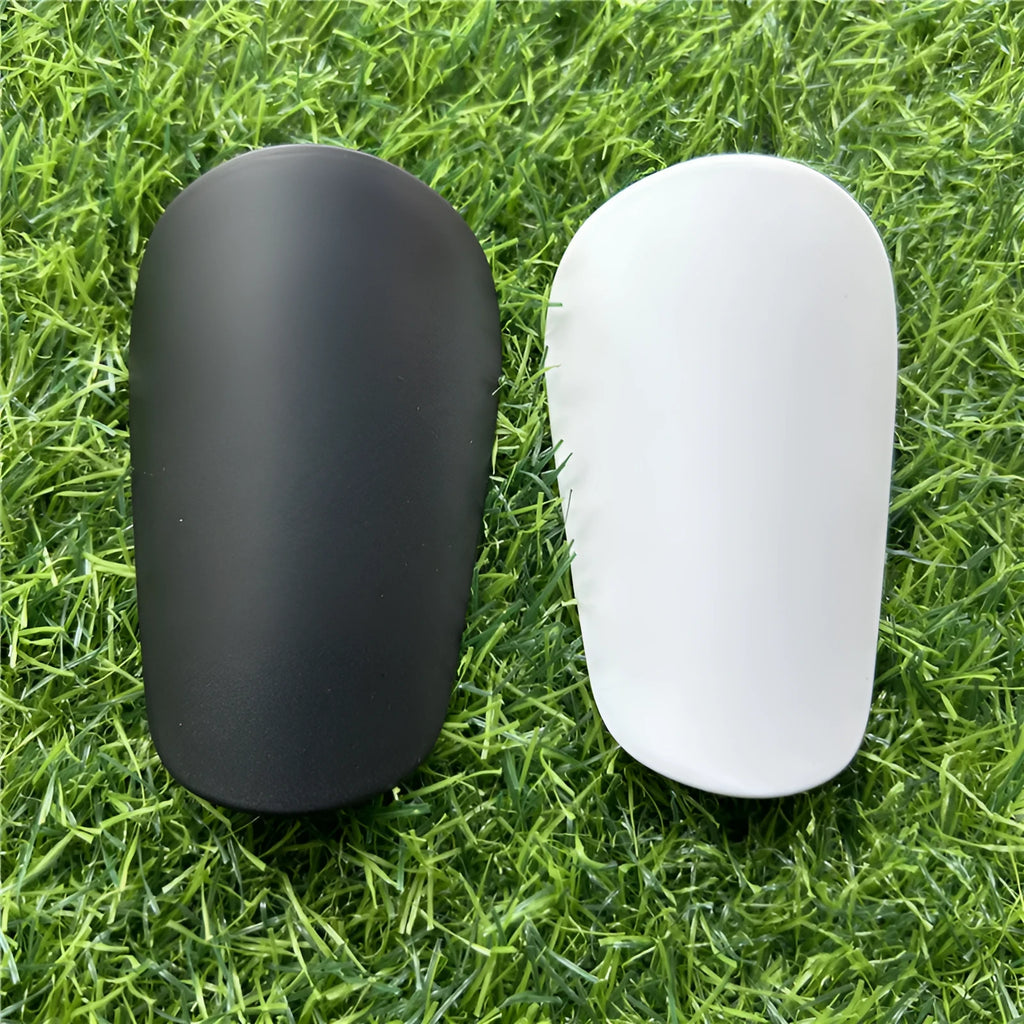 Extra small black and white plastic football shin guards for junior players.