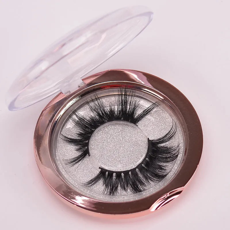 5D mink false eyelashes set with hair storage cap and double-headed brush on a clean surface.