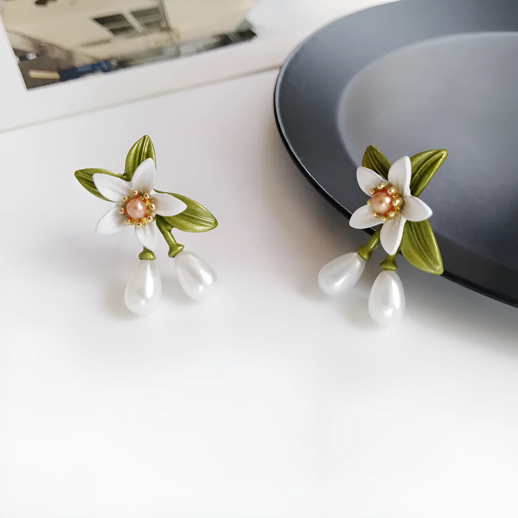 A pair of alloy flower earrings for women, shown in sterling silver needle flowers and flower ear clip styles.