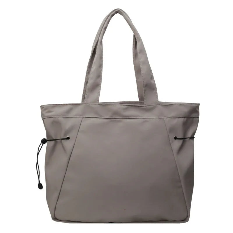 A soft folding Oxford cloth tote bag in a choice of five colours: black, light grey, dark grey, brown, and purple.