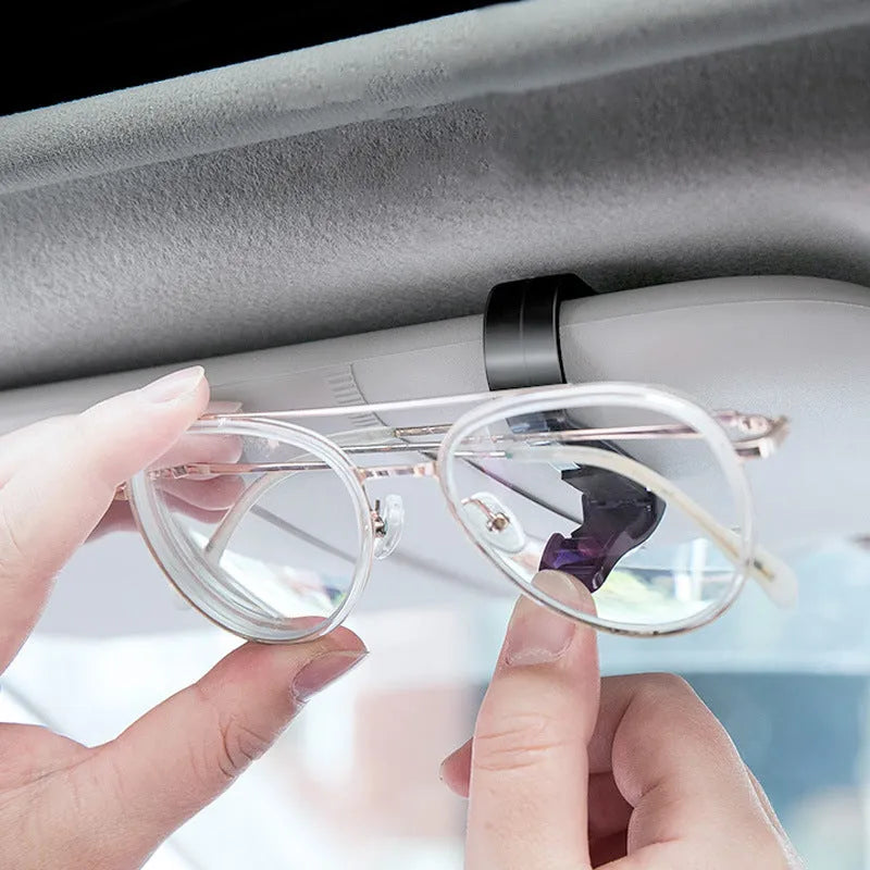 Black plastic car sun visor clip holding sunglasses and cards, measuring 6.5cm by 2.3cm