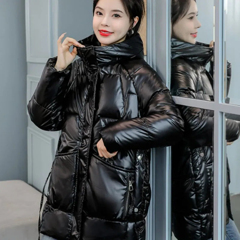 Green loose thick women's winter hooded jacket with long sleeves on a hanger.
