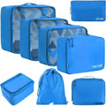 Eight cubic PP travel packing bags in various colours including beige, black, pink, cream, green, navy, and patterned options