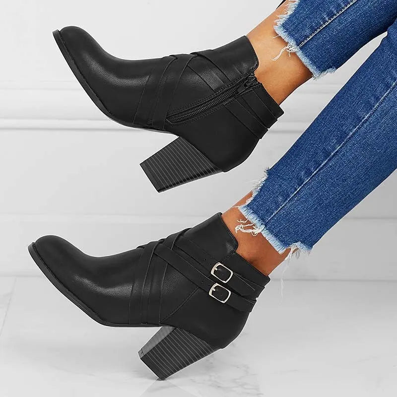 Women's grey ankle boot with a side zipper, buckle detail, and a 7cm rubber heel.