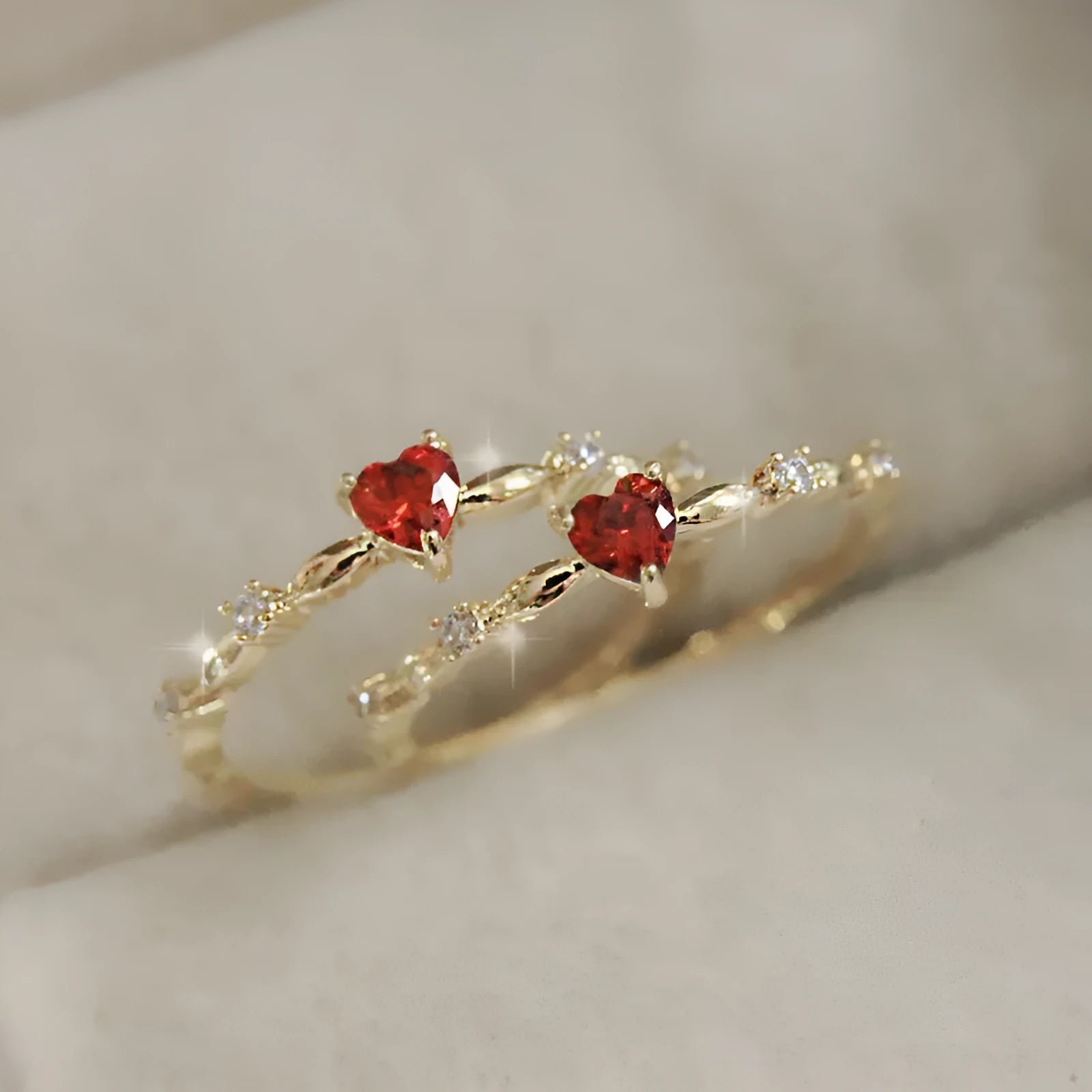 Gold or silver personalised zircon peach heart ring showing five available sizes on a ring sizer.
