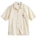 Light apricot coloured men's shirt with a bamboo and floral pattern and a Cuban collar.